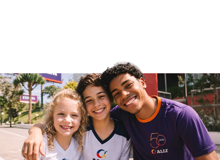 Alunos da Rede Alfa sorrindo em frente à escola